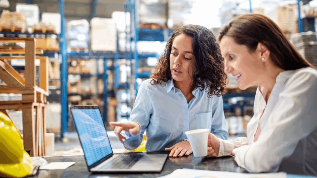 Two logistics professionals reviewing reports on a laptop, highlighting the value of automated 3PL invoicing and activity-based pricing for 3PLs to streamline billing approvals.