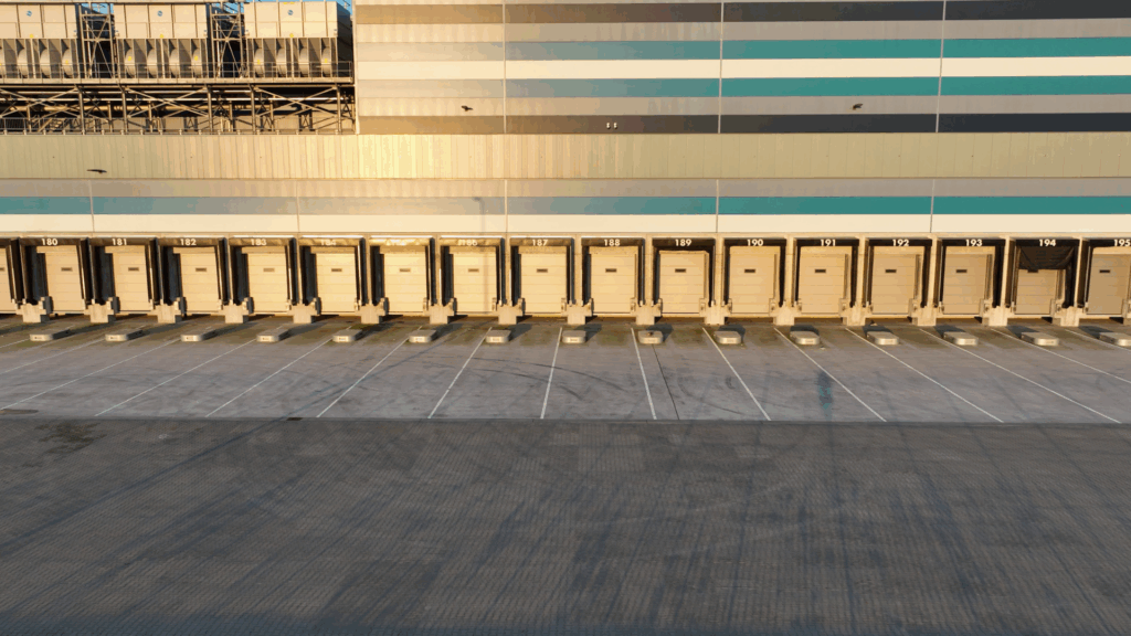 Row of warehouse loading docks in the evening light, representing warehouse heatmaps and layout optimization for improving dock utilization, travel efficiency, and real-time visibility in warehouse operations.