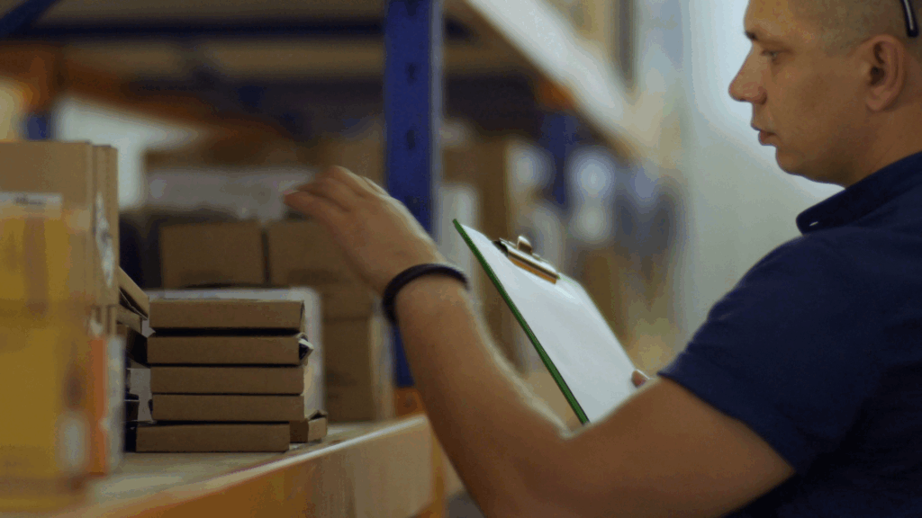 Warehouse associate checking inventory accuracy and WMS data during order fulfillment