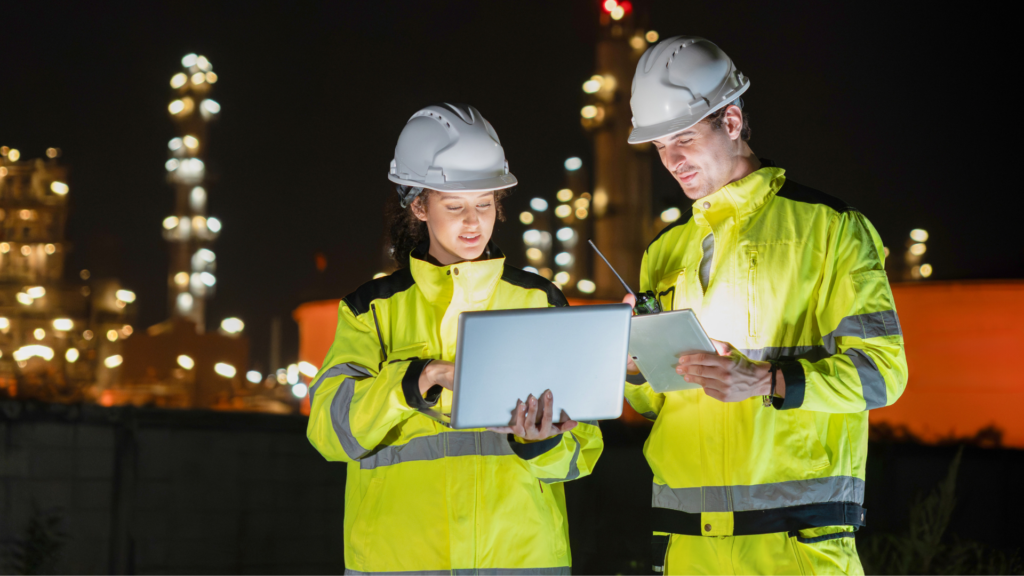 Warehouse managers reviewing system data on laptop and tablet, identifying signs you need a new WMS and evaluating warehouse management system performance