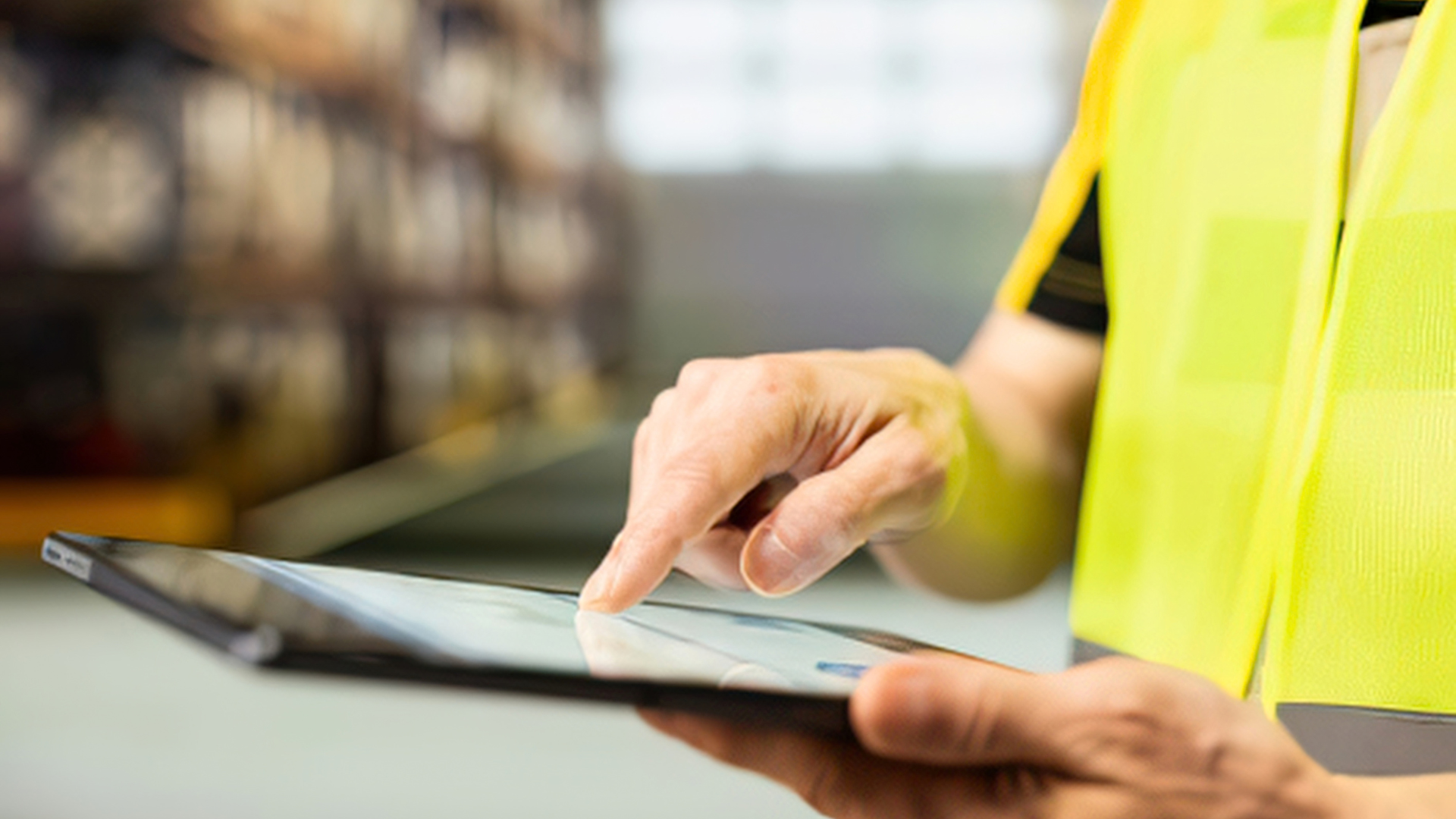 Close-up of a warehouse associate using a tablet, representing real-time data access supported by a warehouse control tower.